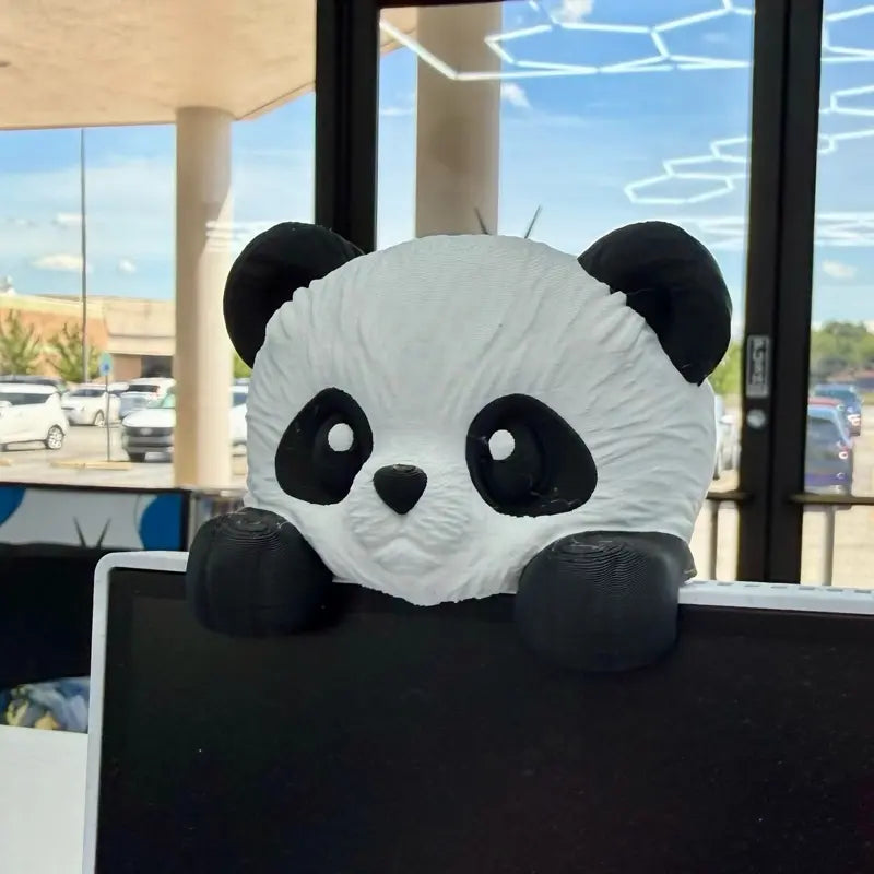 Panda monitor buddy sitting on top of a computer screen